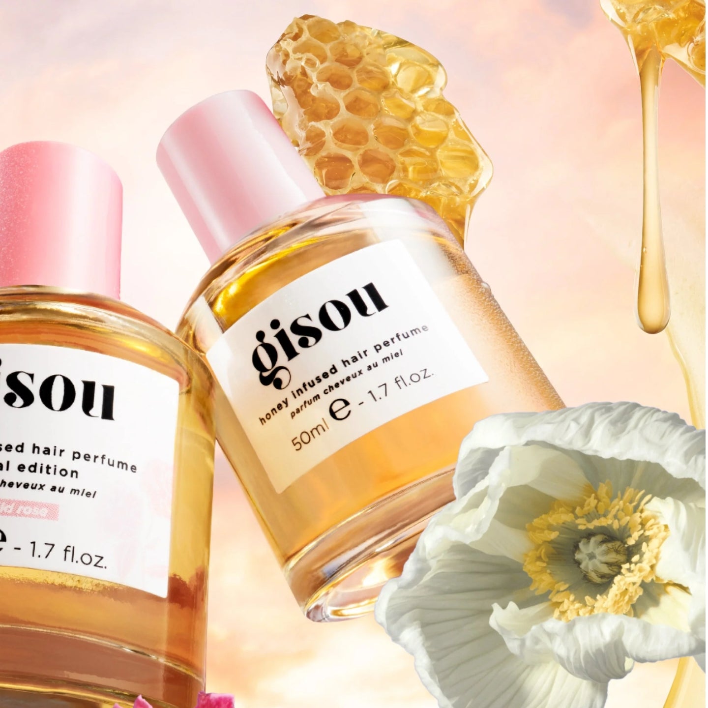 Gisou honey-infused hair perfume bottle with floral and honeycomb elements on a soft pink background