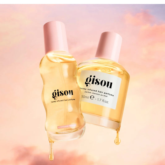 Two bottles of Gisou honey-infused hair perfume on a soft pink background